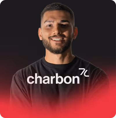 Portrait d'un homme souriant avec une barbe, sur fond noir avec un effet dégradé rouge en bas et le texte « charbon » superposé.